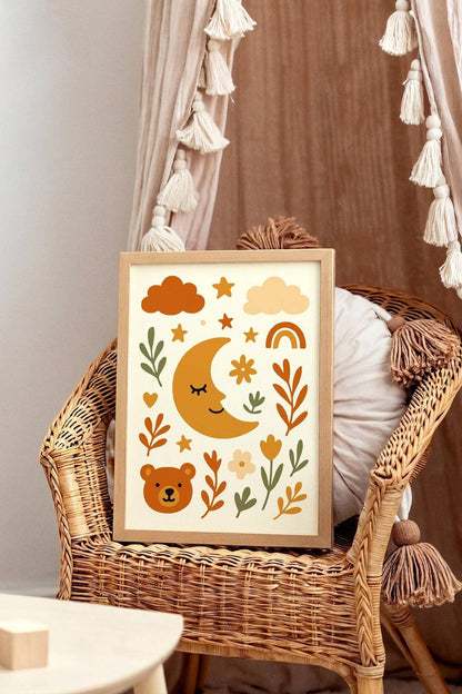 Framed children's wall art with a moon, bear, and floral design on a wicker chair.