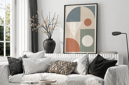 Living room with a white sofa, decorative pillows, and a colorful abstract art piece on the wall.